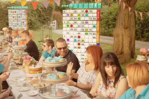 People sitting together and having lunch with bingo boards in the background.