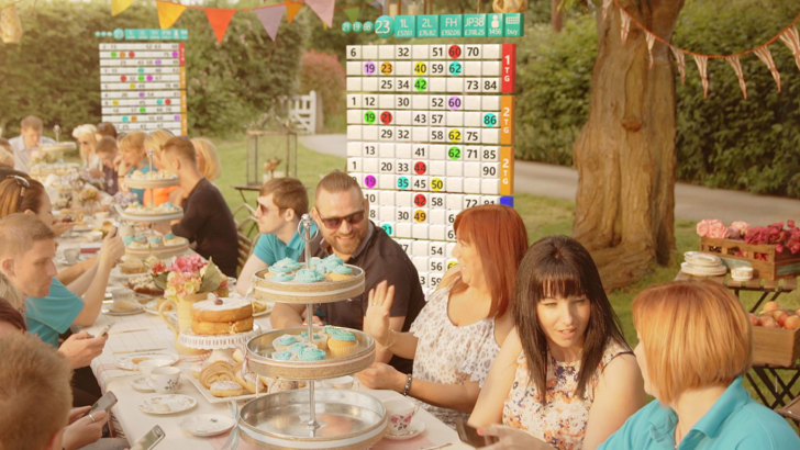 People sitting together and having lunch with bingo boards in the background.